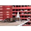 A view of GorillaPRo CA30 instant bonding adhesive on table next to wiring and pipes, with shelves in the background. (Product image)