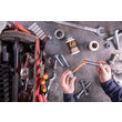 An overhead view showing an MRO professional using the paint brush style applicator of GorillaPro NSCU to apply lubricant to a threaded bolt. (Product image)
