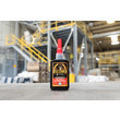 A photo of GorillaPro AT150 threadlocker in the foreground, and an industrial warehouse in the background, out of focus. (Product image)